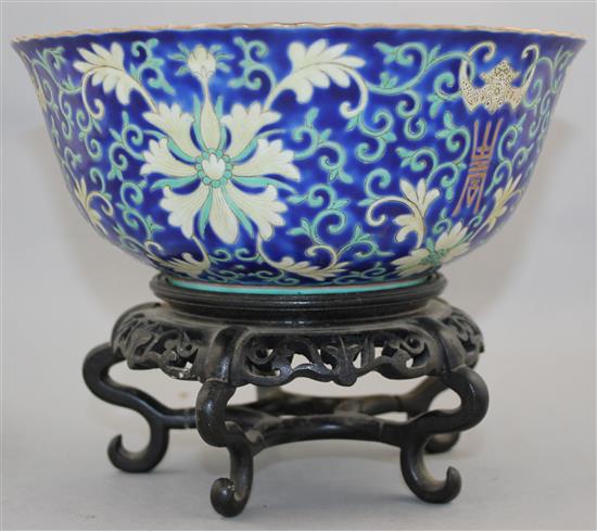 A Chinese blue ground porcelain bowl, Qianlong mark, late 19th / early 20th century, 21.5cm diam., wood stand